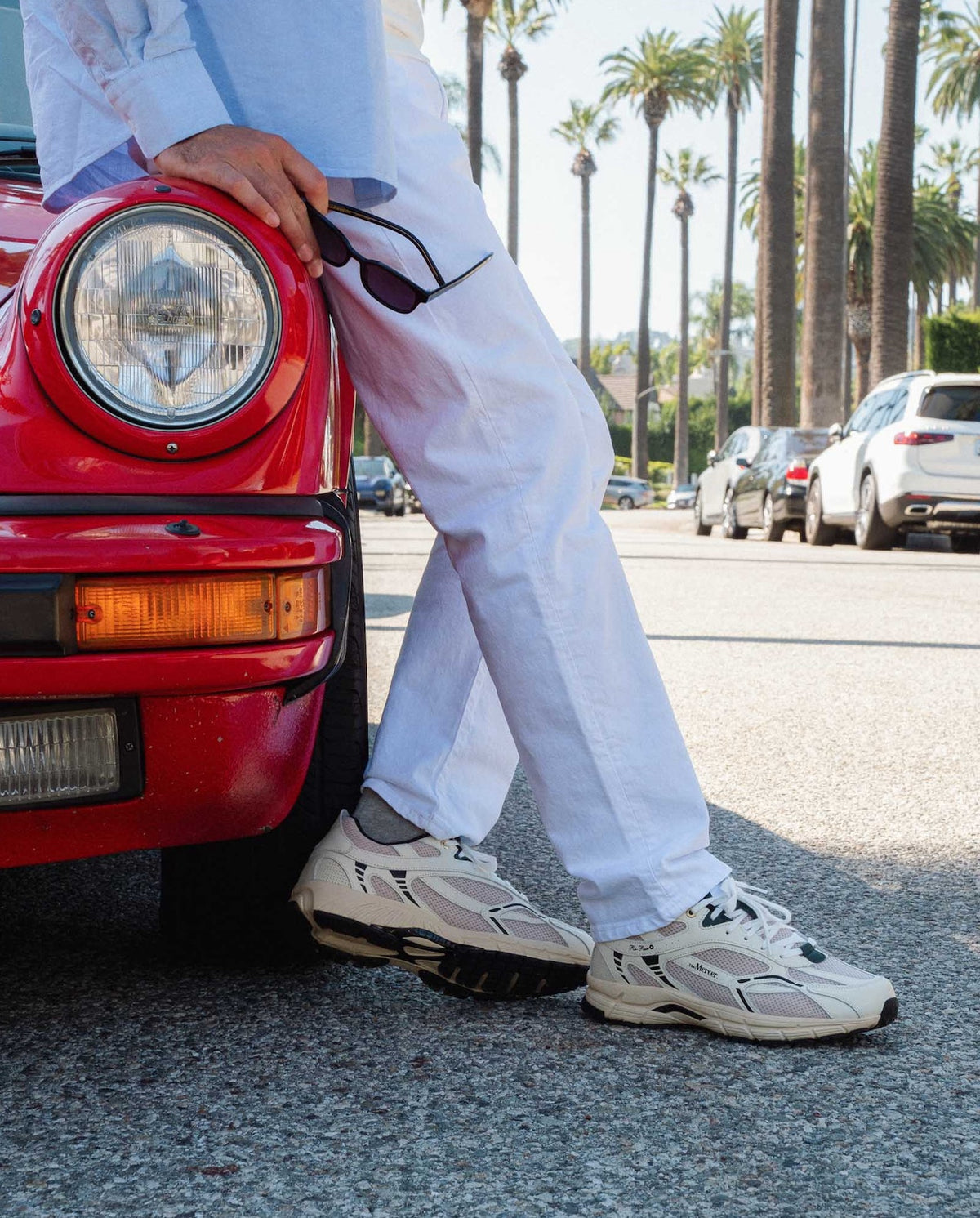 Sneaker The Mercer Brand The Re-Run Classic off white indossate con pantaloni bianchi.